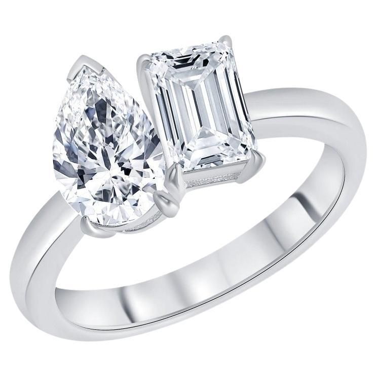 An emerald cut and pear shape two-stone engagement ring on a platinum band 