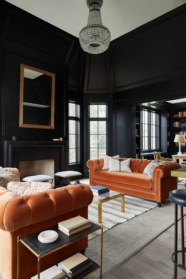 Black living room with orange sofas by interior designer Wendy Labrum