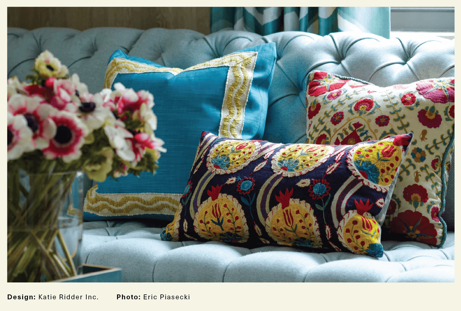 three floral cushions on a blue sofa