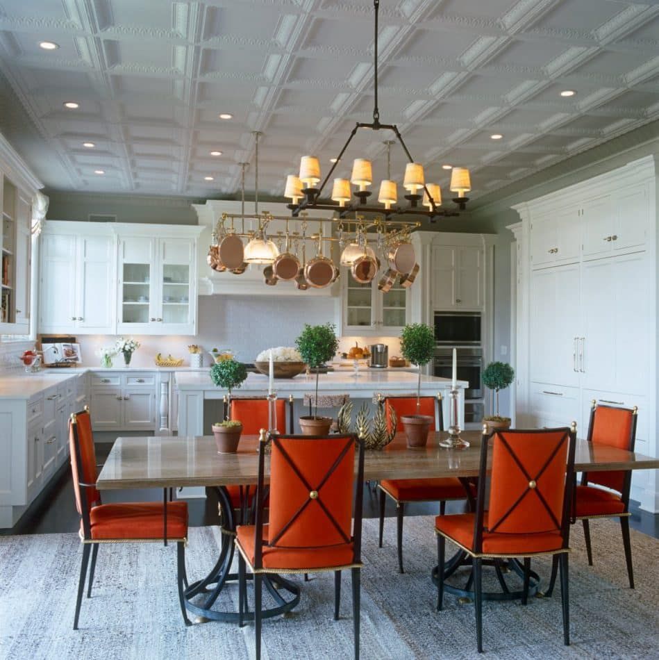 white kitchen with orange dining chairs