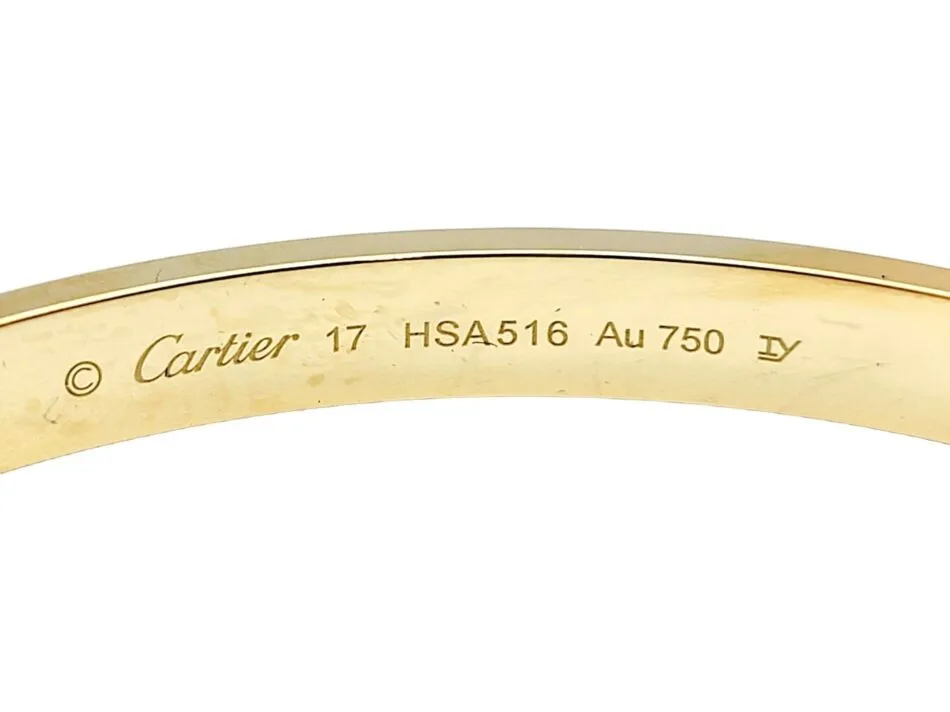 The inside of a yellow-gold Cartier Love bracelet is inscribed with the brand’s logo in cursive, plus symbols indicating its size, its serial number and the purity of the metal with which it’s made. 