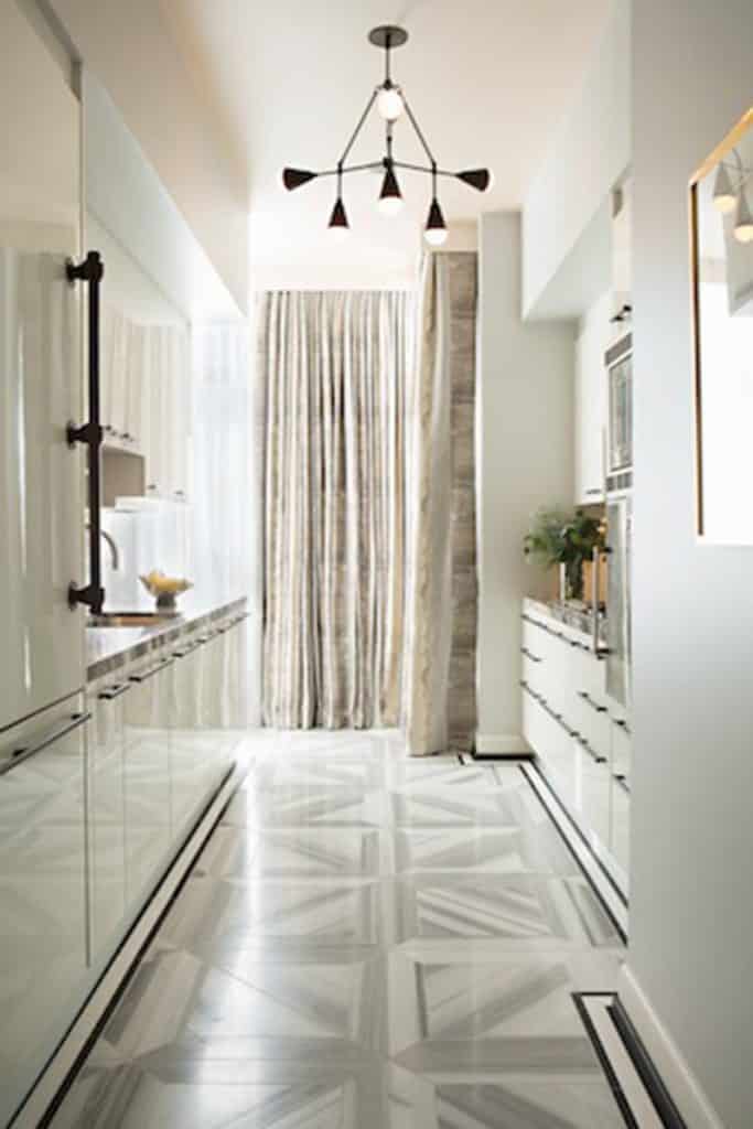 This gray and white floor adds a punch of pattern to this otherwise monochrome kitchen by Woodson & Rummerfield