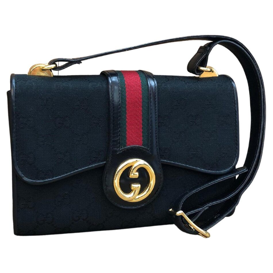 A vintage black Gucci shoulder bag with a red and green Gucci stripe down the front flap that ends in interlocking gold Gs 