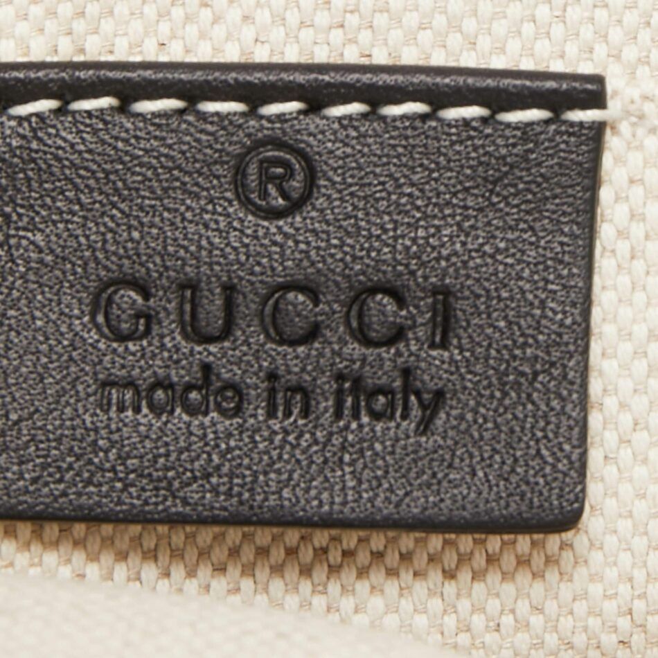 A close-up of an authentic Gucci tag, made from leather with the Gucci name and “made in Italy” stamped on it.