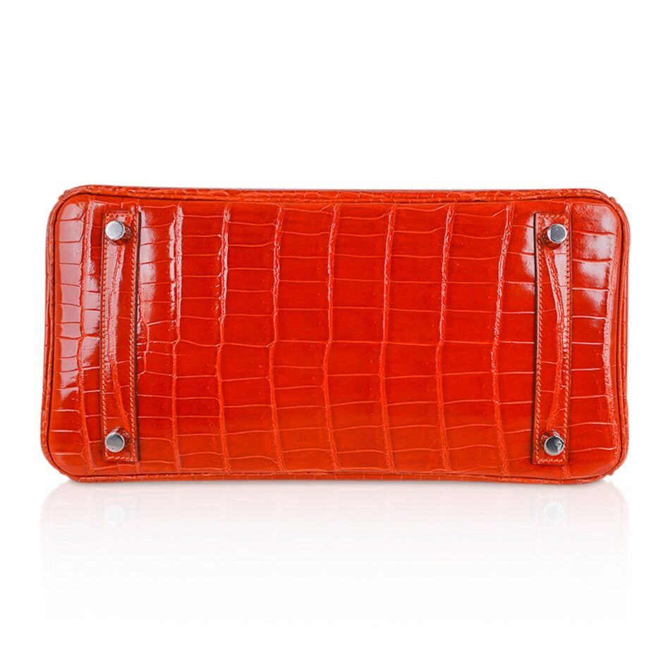 The bottom of an orange alligator skin Hermes Birkin bag 