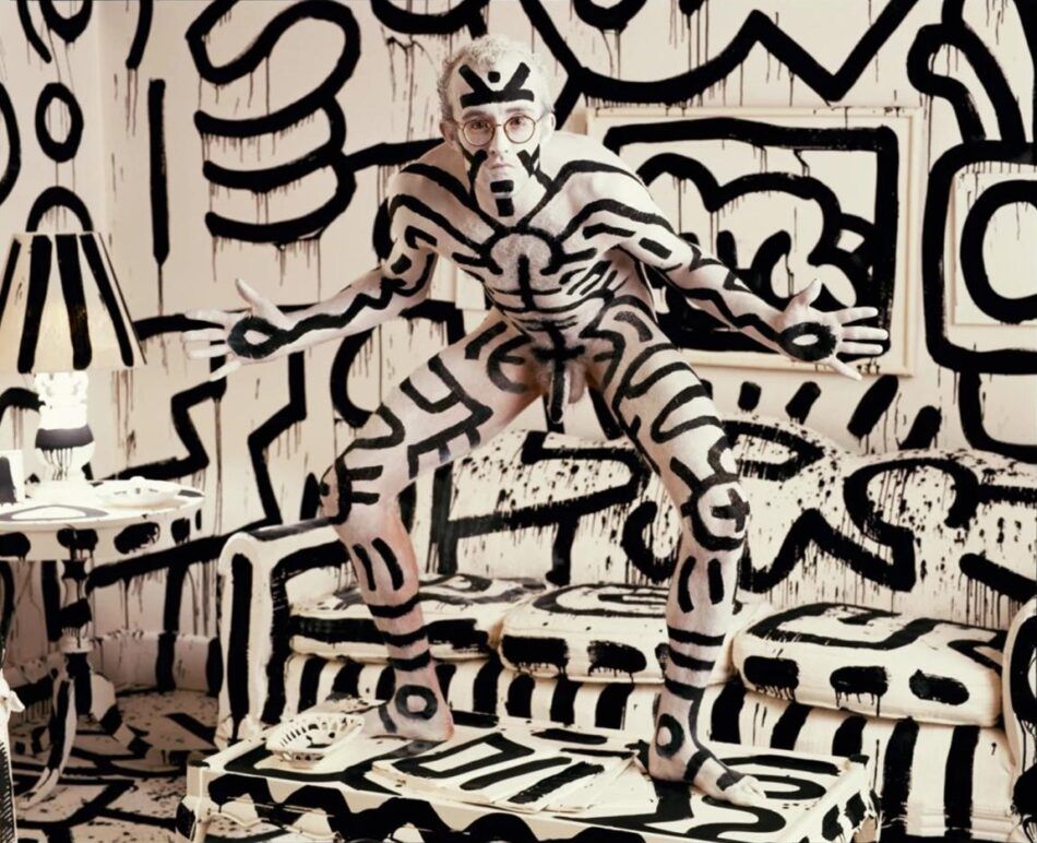 A photograph of Keith Haring painted like his street art by Annie Leibovitz.
