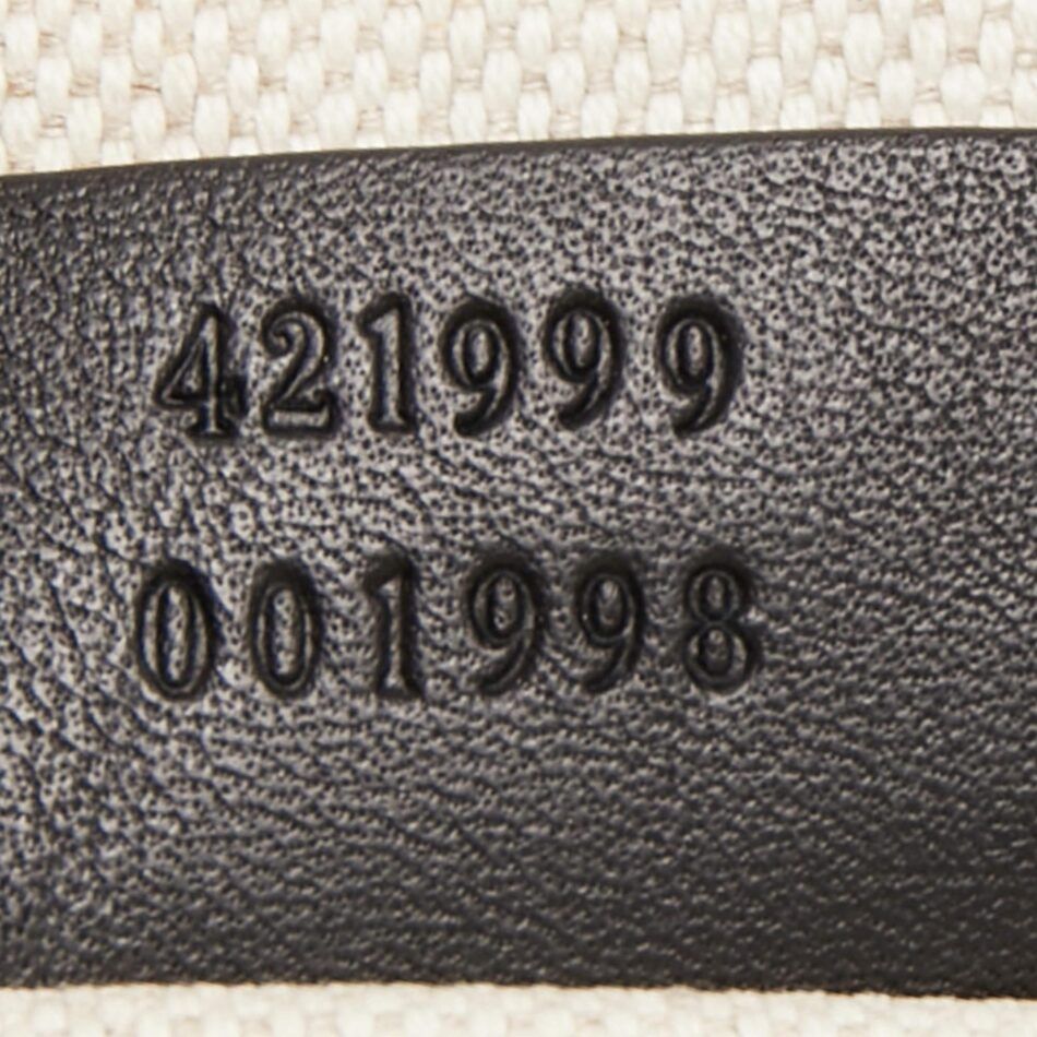 A close-up of the leather tag on a Gucci Dionysus bag, which has two numbers stacked one on top of the other.