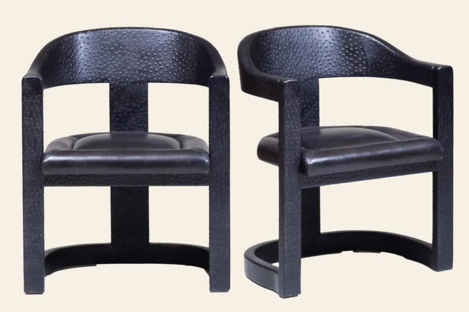 A pair of black Karl Springer Onassis chairs, covered in faux ostrich, part of a set of 10