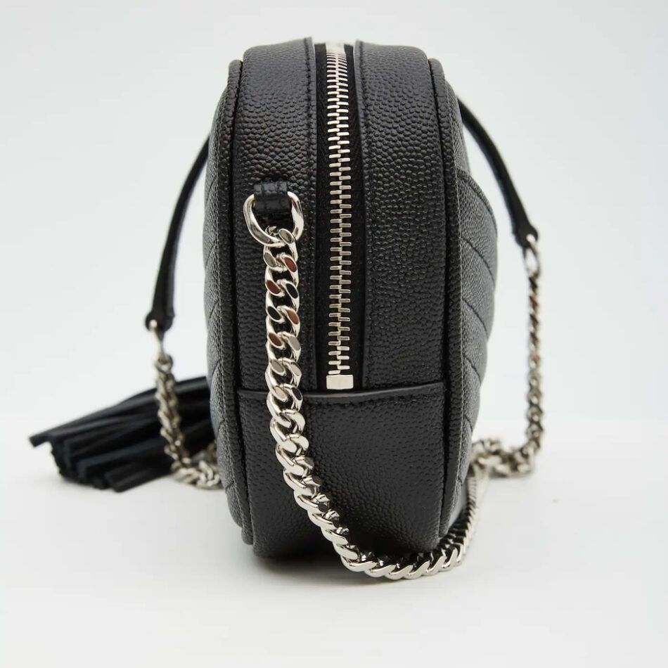 A side view of a black calfskin leather YSL mini Lou camera bag with a thick silver chain strap and silver zipper.